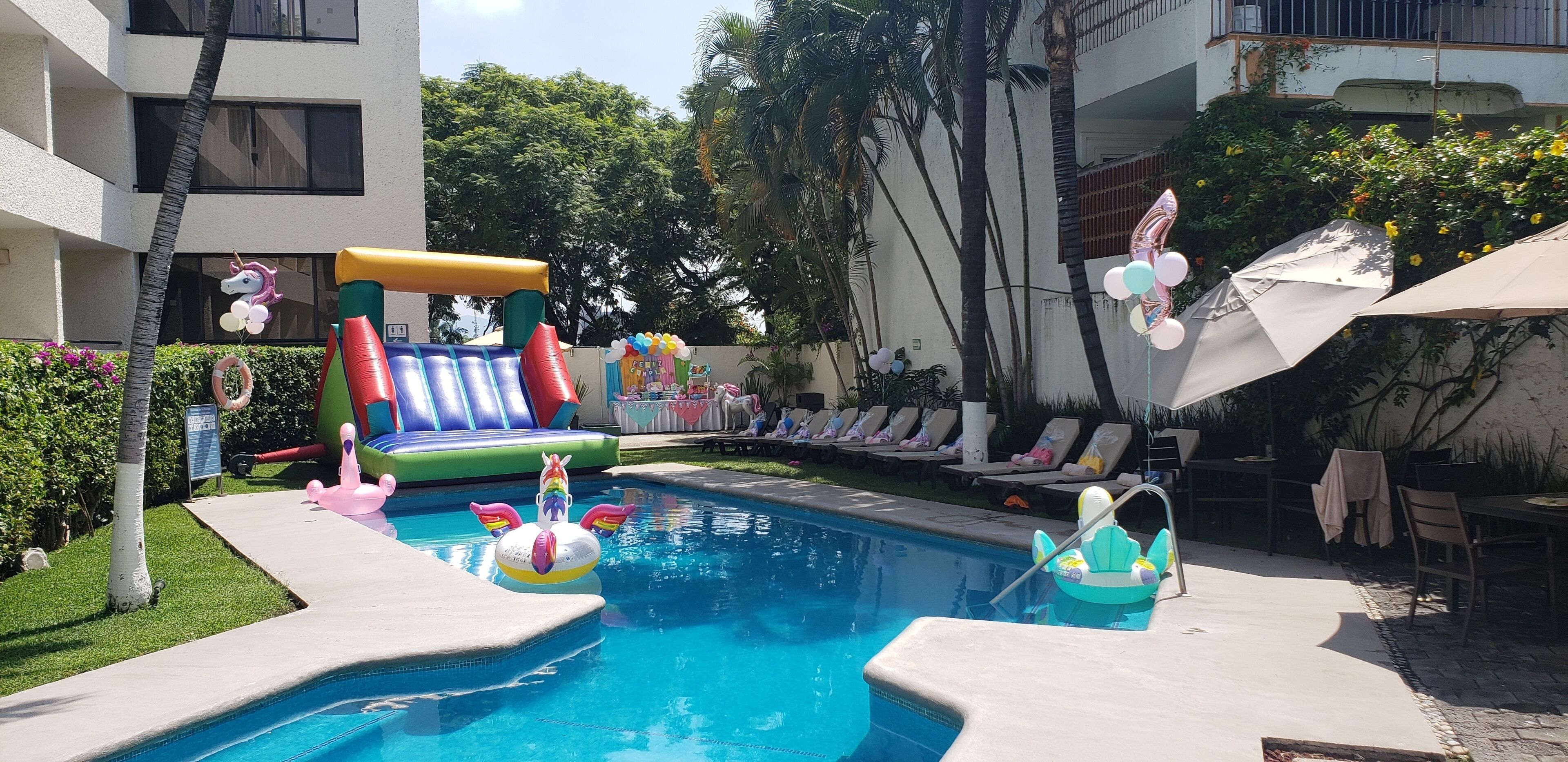 Una piscina con juguetes inflables y sillas de descanso.