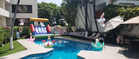 Una piscina con juguetes inflables y sillas de descanso.