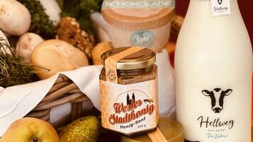 Diverse levensmiddelen zoals appels, champignons en potten honing en melk.