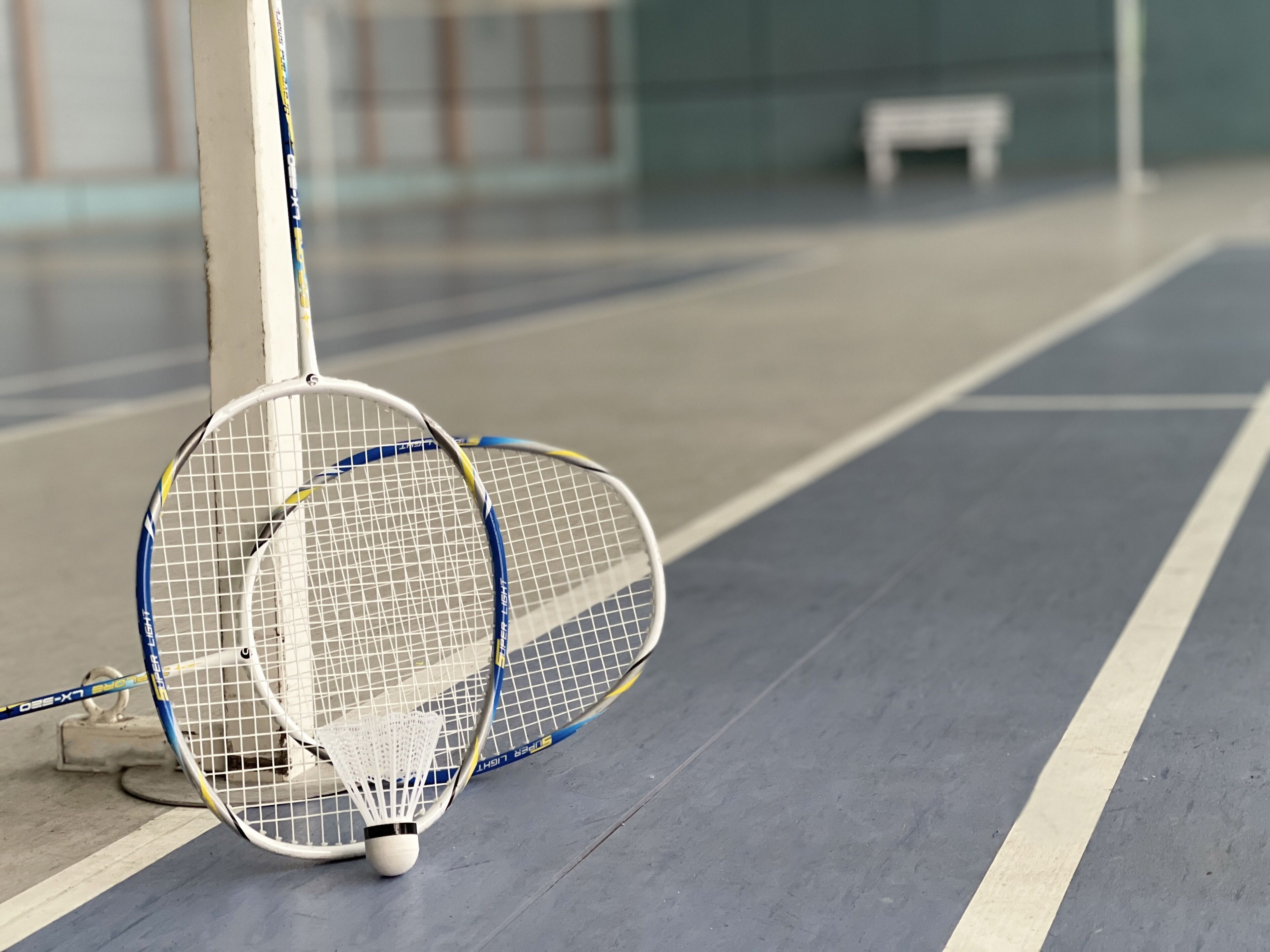 Una raqueta de bádminton apoyada en una pared en un centro deportivo.