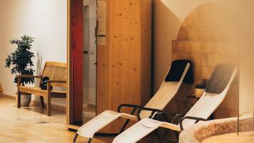 Ein Spa-Raum mit Holzschränken, einer Bank und zwei Liegen.