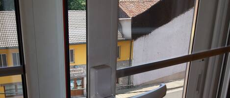 A window with a view of a street and buildings.