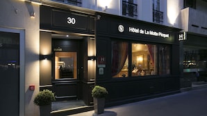 Entrada de un hotel con un cartel que dice "Hôtel de La Motte Picquet" y el número "30" sobre la puerta.