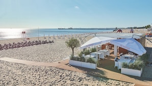 A beachside restaurant with outdoor seating, a view of the sea, and a pier in the background. - Hotel Haffner Resort & SPA - Destigo Hotels (Sopot)