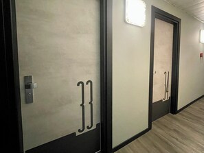 A hallway with doors numbered 33 and 34, each with a light fixture above. - Hotel Perugino (Milan)