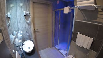Une salle de bain moderne avec une douche à parois de verre, un meuble-lavabo et un porte-serviettes.