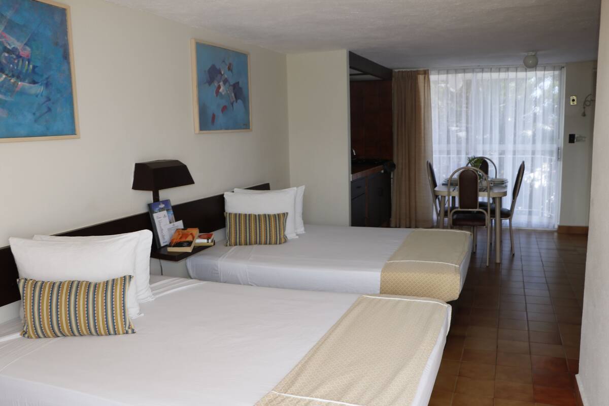 Una habitación de hotel con dos camas, un escritorio y una silla.
