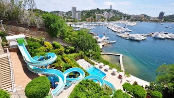 Experience the thrill of our water park with multiple slides, surrounded by lush greenery and a scenic marina.