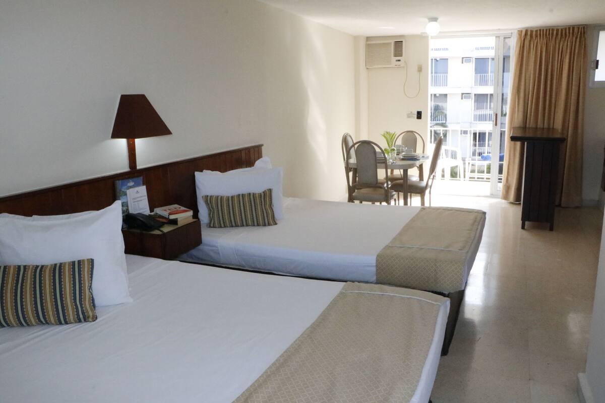 Una habitación de hotel con dos camas, un escritorio y una silla.
