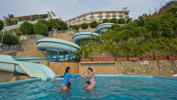 Relax by the pool surrounded by lush greenery and enjoy a thrilling water slide experience.