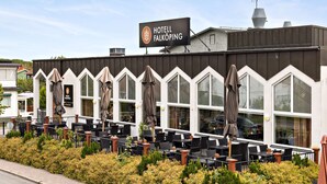 A hotel with outdoor seating and a sign reading "HOTEL FALKÖPING".