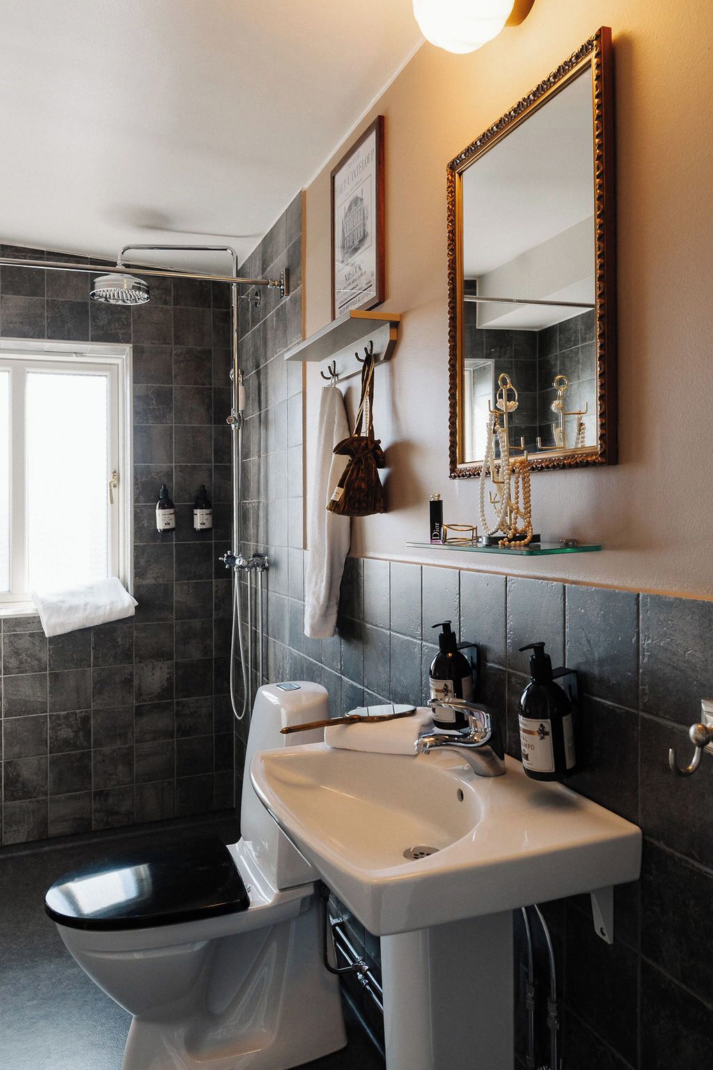 Une salle de bain équipée d’une douche, de toilettes, d’un lavabo et d’un miroir.