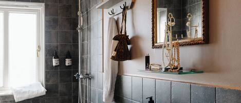 Une salle de bain équipée d’une douche, de toilettes, d’un lavabo et d’un miroir.
