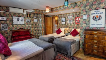 A room with two beds, a dresser, and a mirror.