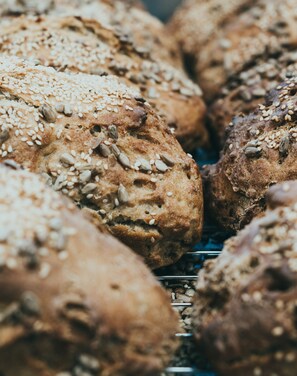 A close-up of various breads with seeds on top.