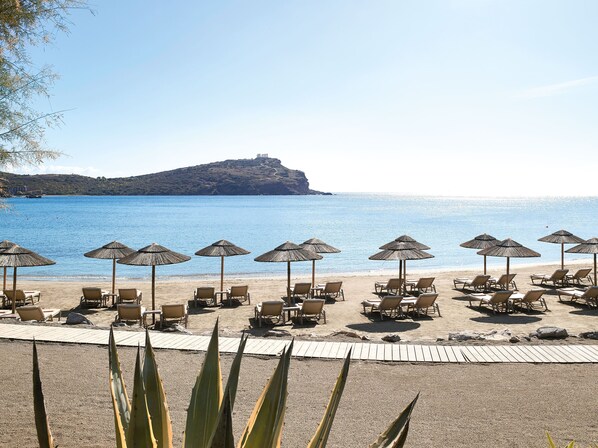 Aan een privéstrand, ligstoelen, parasols, strandlakens