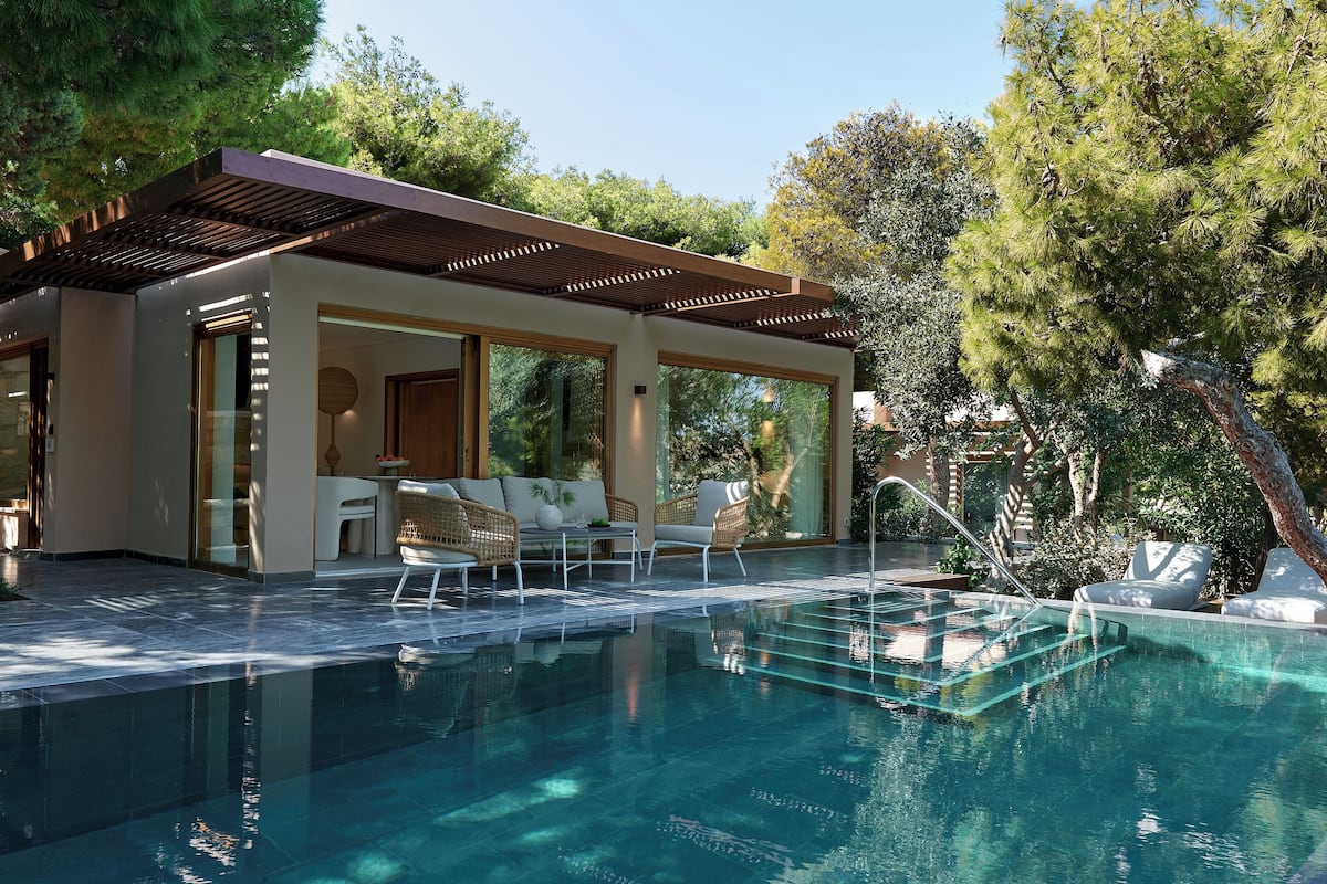 Ein moderner Poolbereich im Freien mit Liegestühlen und einer überdachten Sitzgelegenheit.