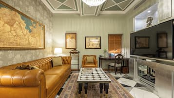 A living room with a brown leather sofa, a patterned rug, a coffee table, a fireplace, and a television.