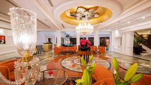 A spacious lobby with a grand chandelier, plush seating, and a decorative floor design. - The Claridges, New Delhi (New Delhi)