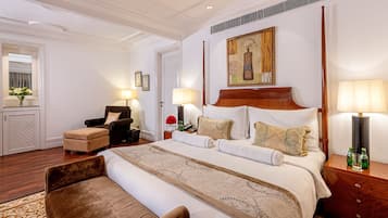 Une chambre d’hôtel avec un grand lit, une chaise, une table de chevet et un tableau au mur.