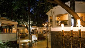 A stone wall with candles, a staircase, and a building with a balcony. - The Claridges, New Delhi (New Delhi)