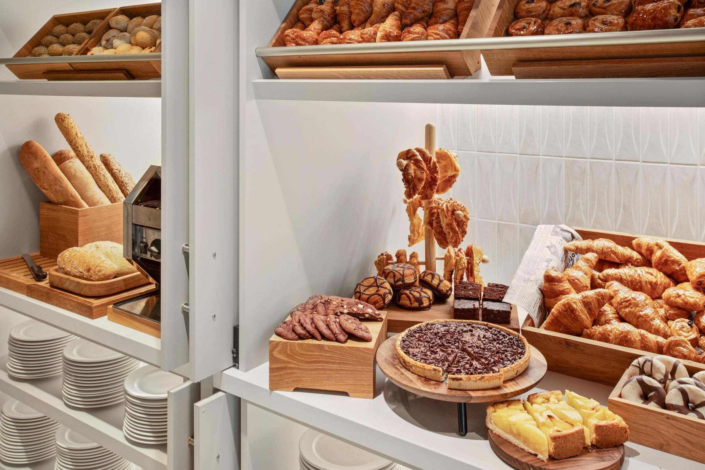 A bakery display with various baked goods, including bread, pastries, and desserts.