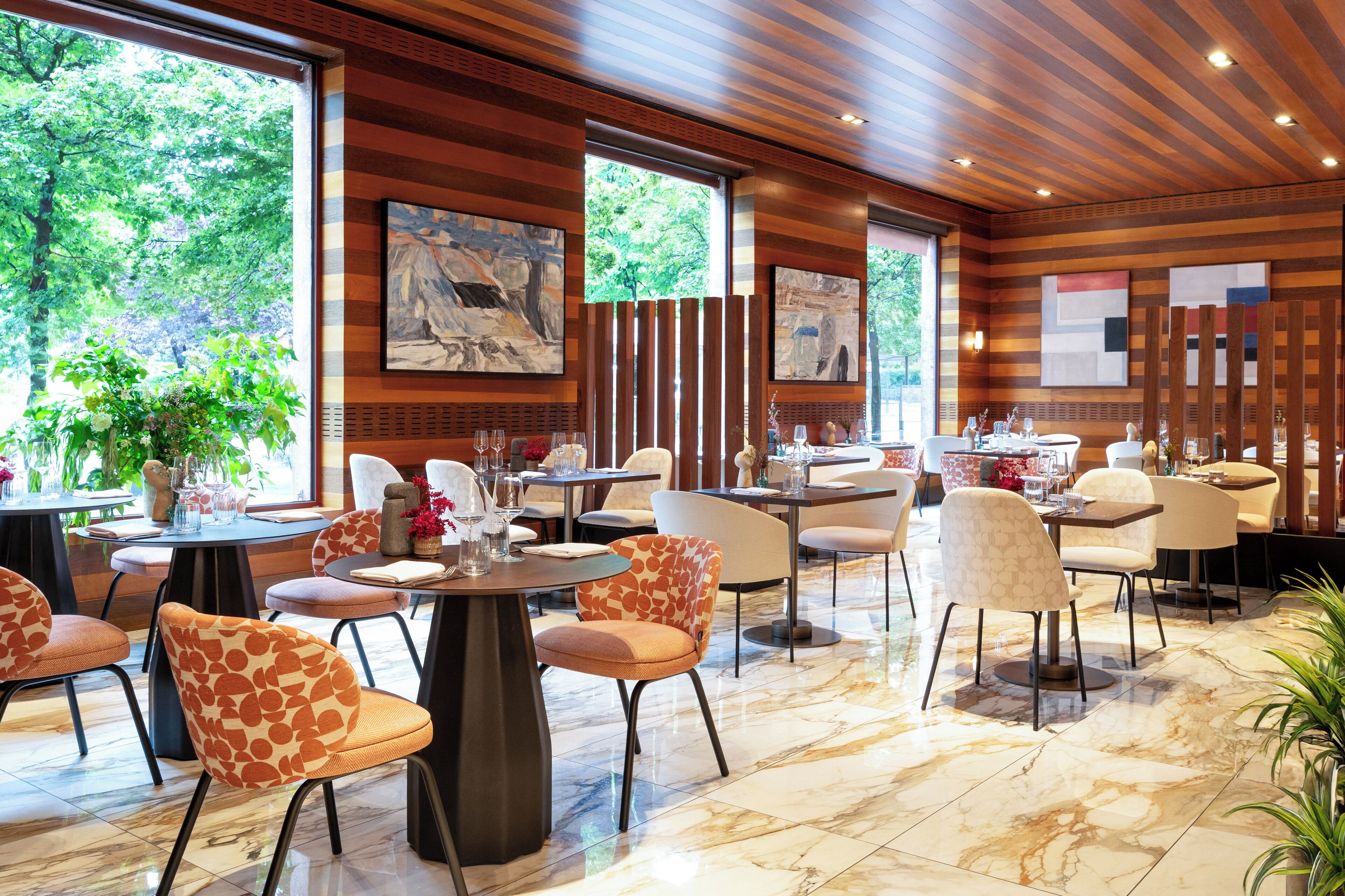 Un restaurant moderne avec des lambris en bois, un sol en marbre et différents types de sièges.