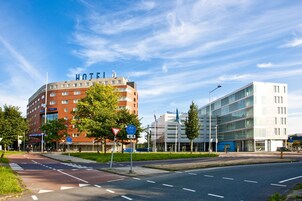 Ein Hotel mit einer gebogenen Fassade, mehreren Etagen und einem gut sichtbaren 'HOTEL'-Schild.