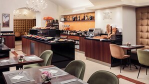 A hotel dining area with a buffet setup, seating arrangements, and a bar area. - Kosher Hotel KING DAVID Prague (Prague)