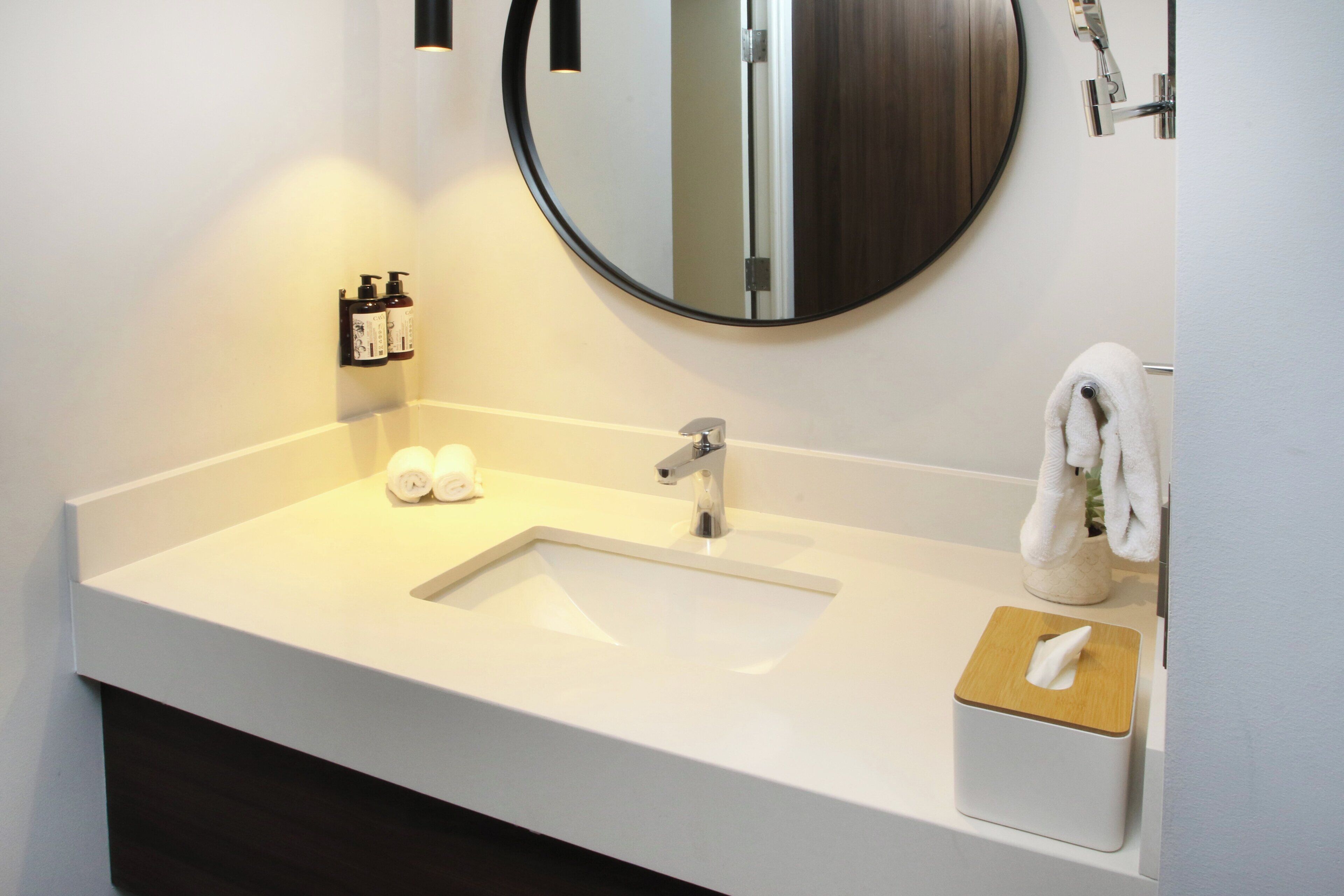 A bathroom with a white sink, a mirror, and a towel rack.