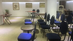 A room with a long table and chairs, a small round table with a chair, and a potted plant. - Villa la Tour (Nice)