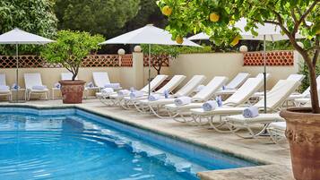 Alberca al aire libre por temporada y sombrillas en la alberca