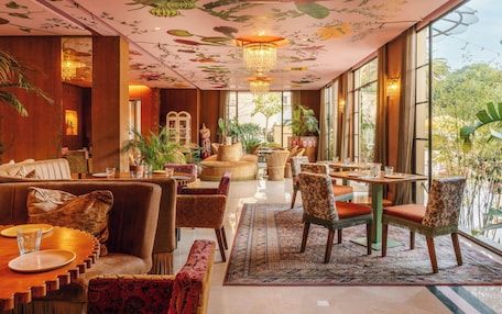 A room with a dining area, seating arrangements, and a view of the outdoors.