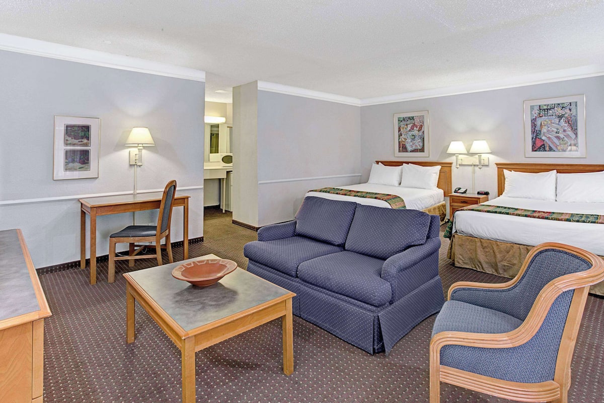 Ein Hotelzimmer mit einem Bett, zwei Sofas, einem Tisch und einem Sessel.