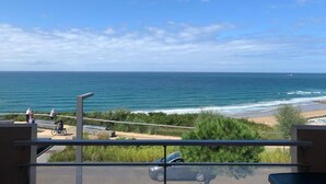 Un balcon avec vue sur l’océan et la plage.
