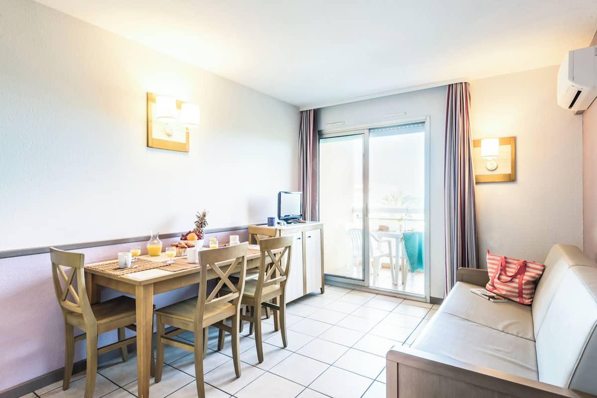 Ein Hotelzimmer mit Essbereich, einer Couch und einem Fernseher.