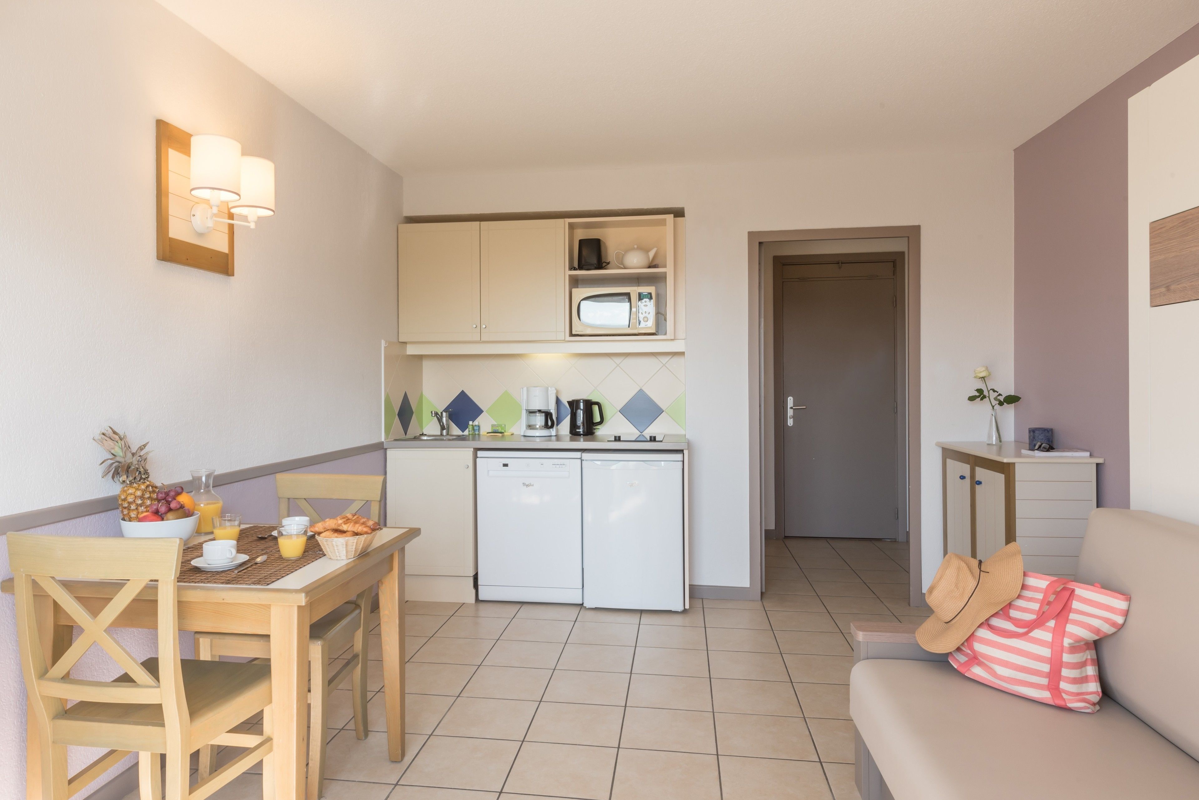 A compact kitchen with a microwave, coffee maker, and a small refrigerator.