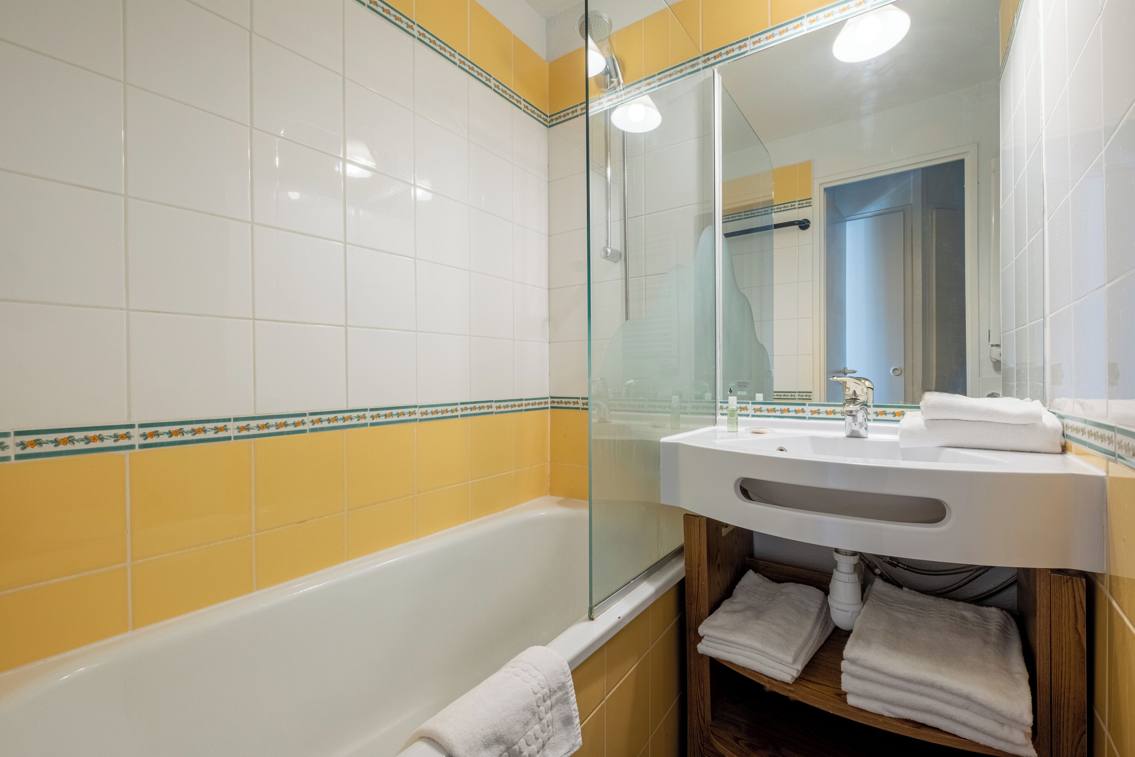 Une salle de bain avec une baignoire, un lavabo et un miroir.