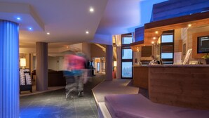 Eine moderne Lobby mit einer Rezeption, einer Sitzecke und einem großen Fenster.