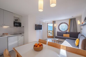 Une cuisine moderne équipée d’un four à micro-ondes, d’un lave-vaisselle et d’un coin repas avec une table et des chaises.