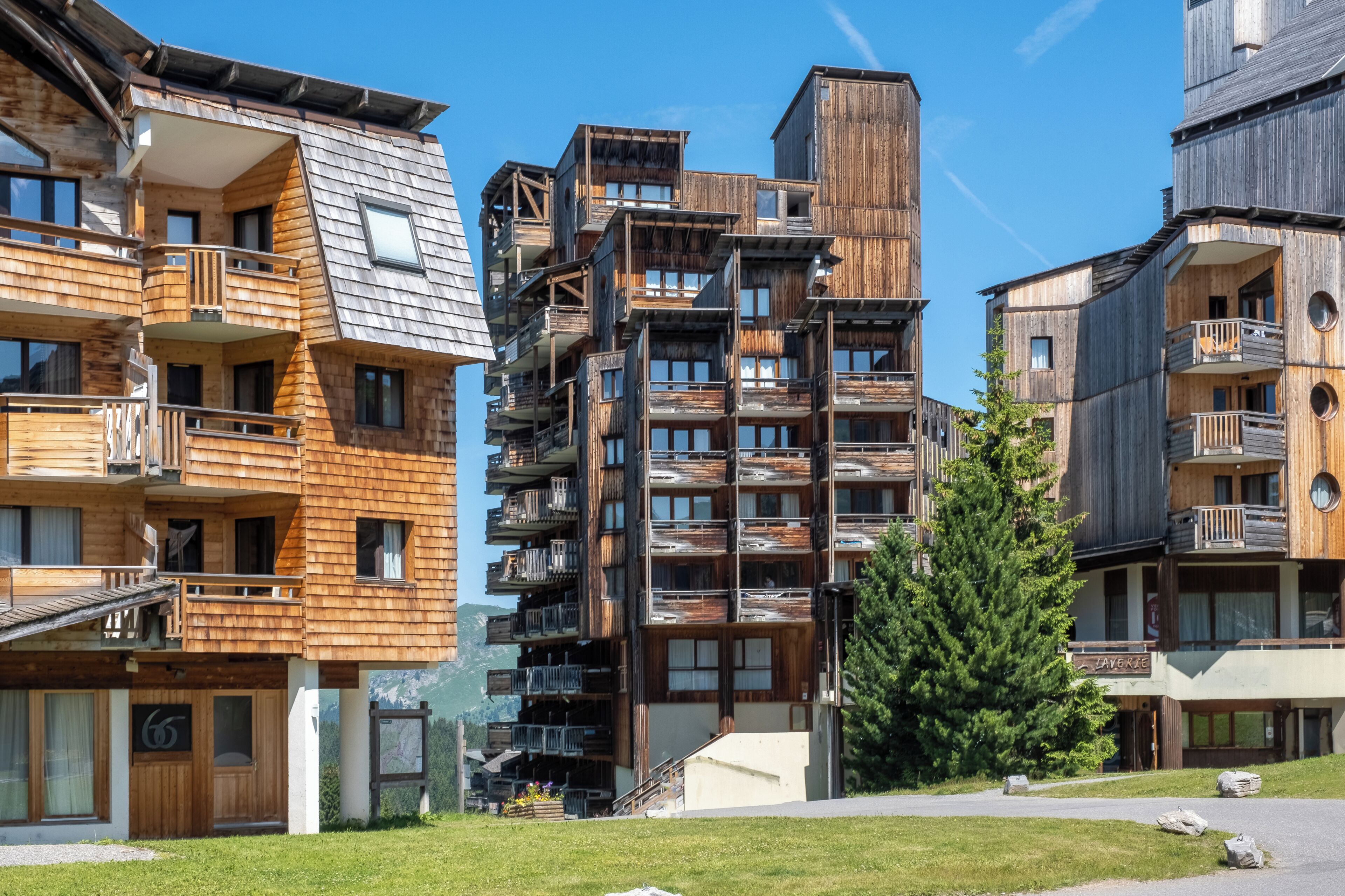 Un edifici de fusta de diversos pisos amb balcons i un telefèric visible al fons.