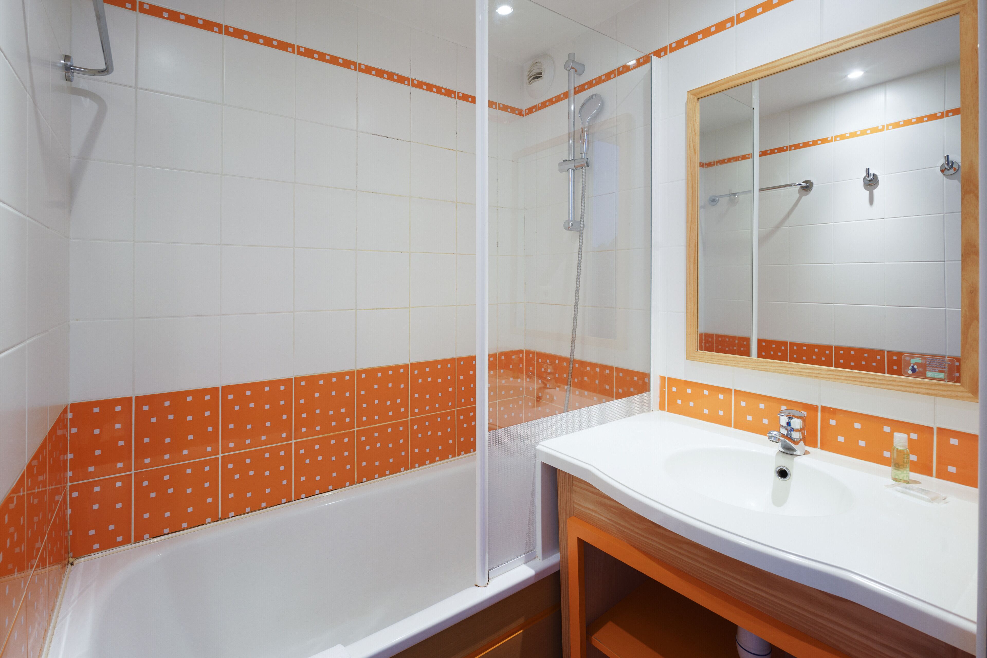 A bathroom with a bathtub, shower, and sink.