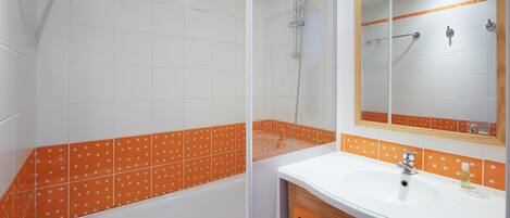 A bathroom with a bathtub, shower, and sink.