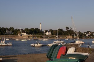 Un port avec des bateaux, un phare et des maisons en arrière-plan.