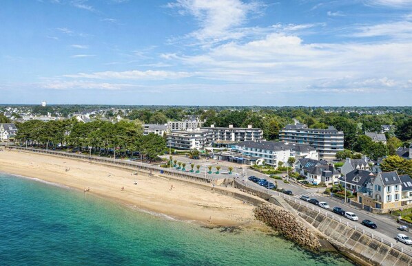 A coastal hotel with multiple buildings, a sandy beach, and a clear blue sky. - Pierre & Vacances Résidence La Corniche de la Plage (Benodet)