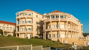 A multi-story hotel with balconies and a red roof. - Résidence Eugénie (Biarritz)