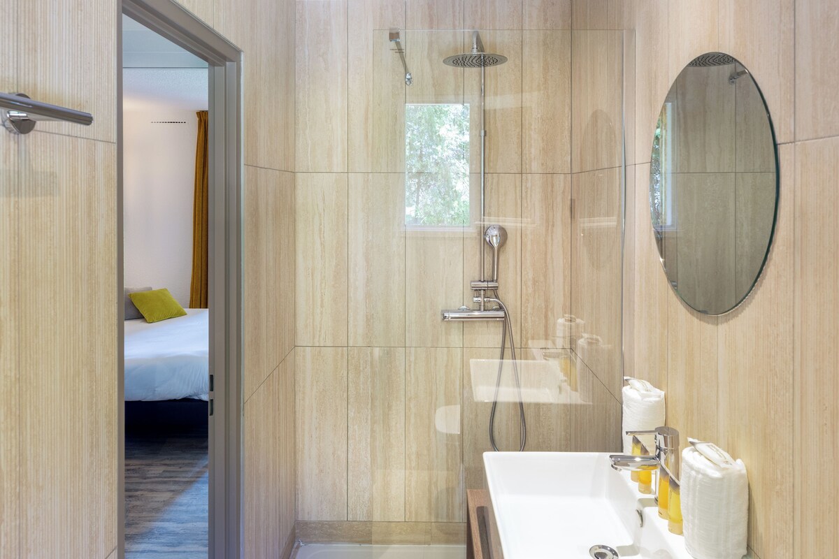 A modern bathroom with a shower, sink, and mirror.