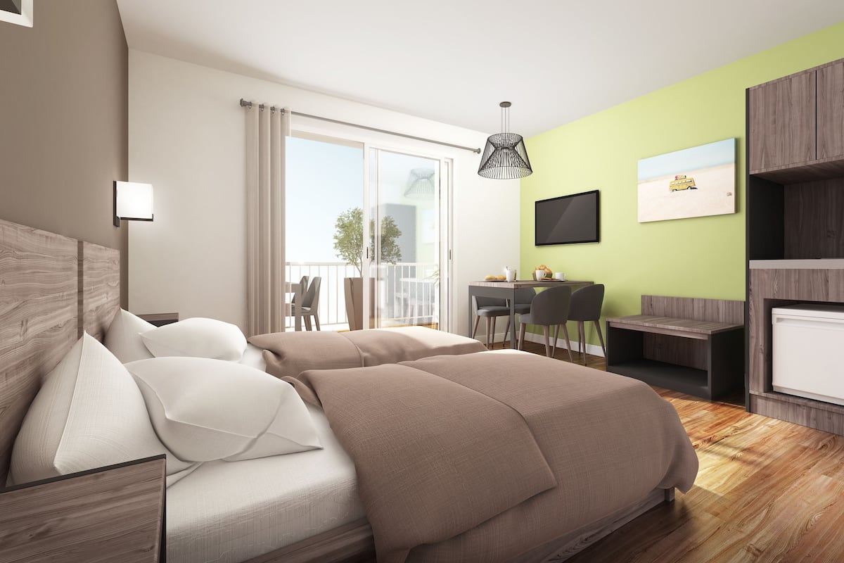 A modern bedroom with a large bed, a desk, and a TV.