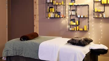 Relax in comfort with a massage table, toiletries, and warm string lights.