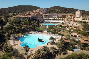 Una piscina al aire libre de temporada, sombrillas, tumbonas
